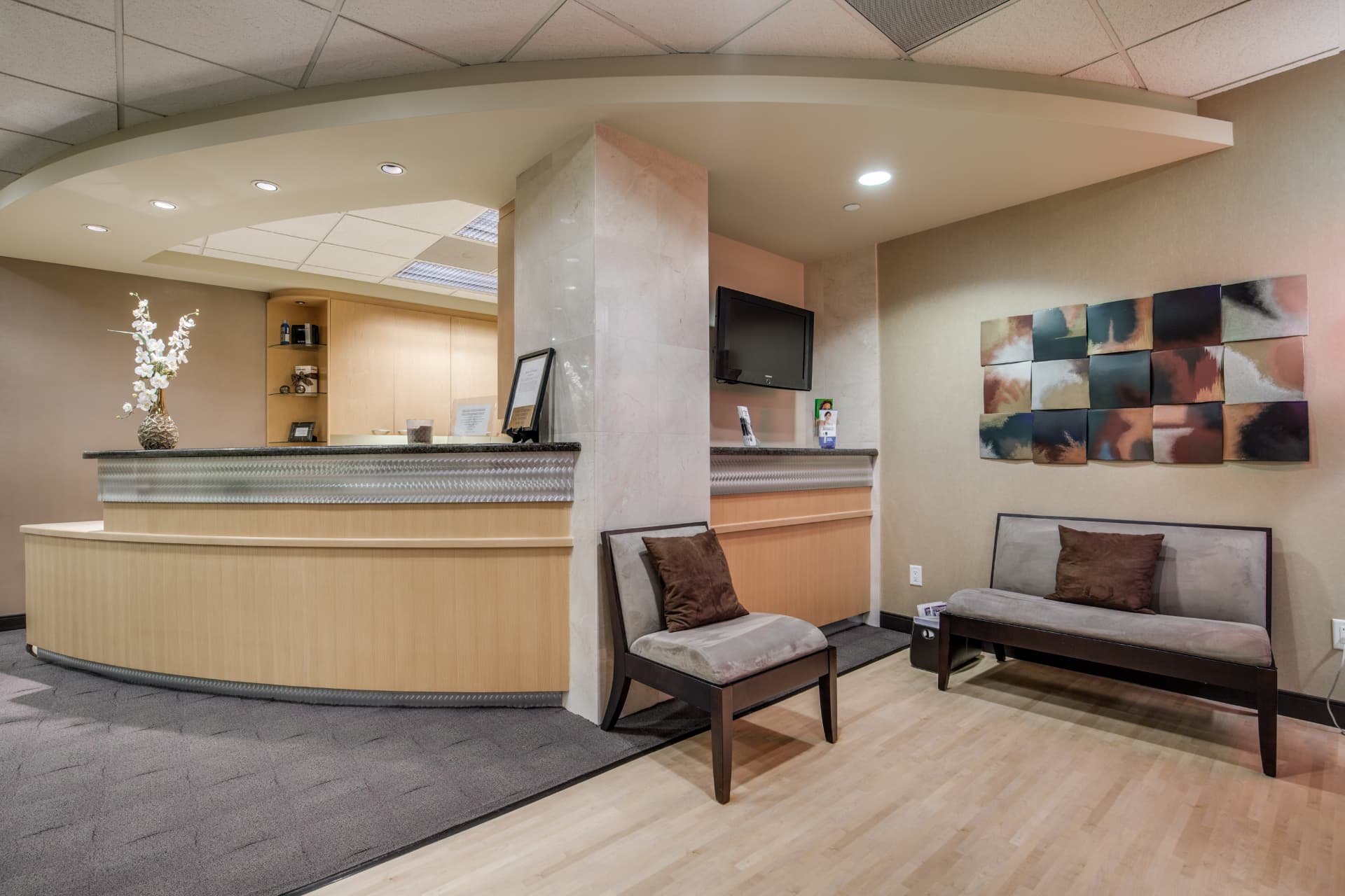 Uptown Dentistry waiting room with orchid-topped reception counter and comfortable seating