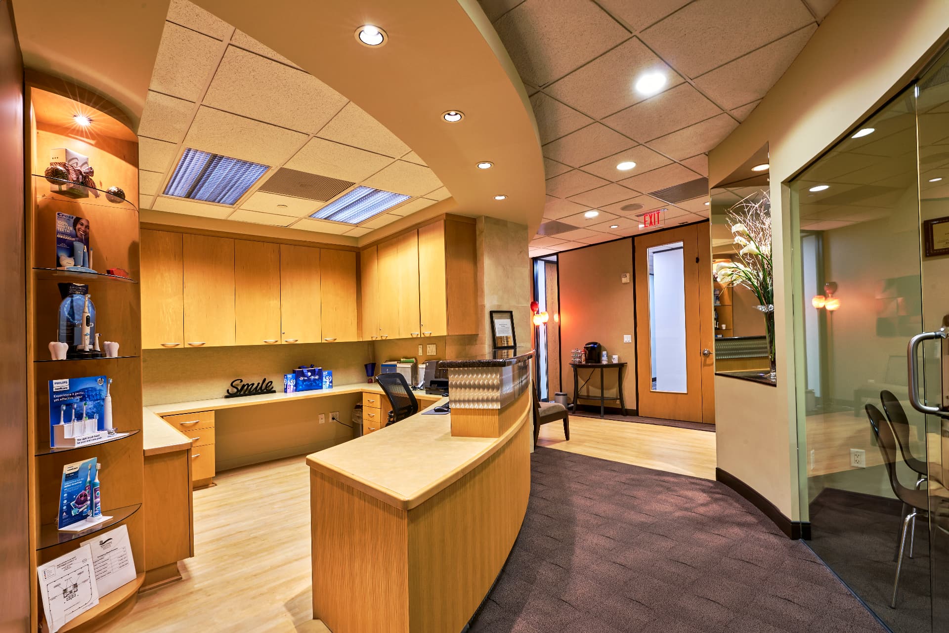 Front office at Uptown Dentistry with the check-in counter, electric toothbrush display and glass-walled consultation room