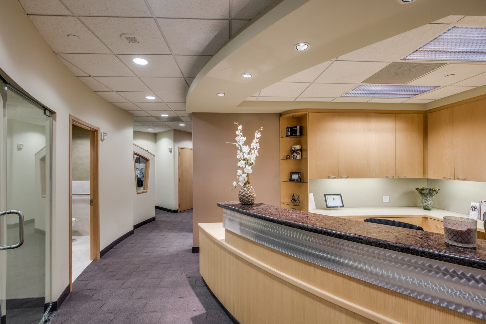 Granite-topped front desk at Uptown Dentistry looking down the hallway toward the treatment rooms